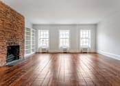 Thumbnail 12 of 18 - an empty living room with a brick fireplace and white walls
