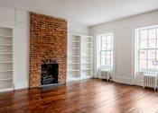 Thumbnail 18 of 18 - an empty room with a brick fireplace and white bookshelves