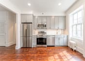 Thumbnail 10 of 18 - a kitchen with gray cabinets and a wood floor