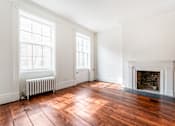 Thumbnail 4 of 18 - an empty living room with two windows and a fireplace