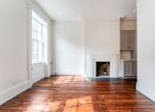 Thumbnail 3 of 18 - a living room with white walls and a fireplace