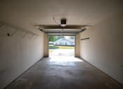 Thumbnail 37 of 37 - an empty garage with a white house in the background