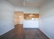 Thumbnail 34 of 37 - an empty living room with a kitchen in the background