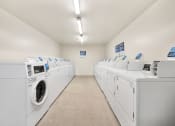 Thumbnail 10 of 25 - Several machines for laundry in the community laundry room at Somerset Apartments in Marion, IN.