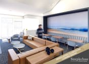 Thumbnail 3 of 28 - a man walking through a living room with a large screen on the wall