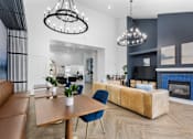 Thumbnail 62 of 65 - Modern resident clubhouse featuring a cozy fireplace, lounge seating, coworking tables, designer lighting, and upscale finishes at Steeplechase at Shiloh Crossing Apartments in Avon, Indiana.