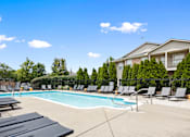 Thumbnail 53 of 65 - Resort-style outdoor swimming pool surrounded by lounge chairs, a spacious sundeck, and beautifully landscaped grounds at Steeplechase at Shiloh Crossing Apartments in Avon, Indiana.