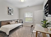 Thumbnail 33 of 65 - Versatile apartment flex space featuring a daybed, dedicated workspace, plush carpeting, and a large window with natural light at Steeplechase at Shiloh Crossing Apartments in Avon, Indiana.