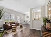Thumbnail 51 of 65 - Bright open-concept apartment featuring a spacious living room, wood-style flooring, breakfast bar, and dining area at Steeplechase at Shiloh Crossing Apartments in Avon, Indiana.