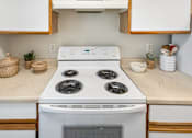 Thumbnail 8 of 65 - Kitchen Stove and White Cabinetry at Steeplechase at Shiloh Crossing