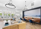 Thumbnail 64 of 65 - Modern resident clubhouse featuring comfortable lounge seating, coworking tables, vaulted ceilings, and views of the resort-style pool at Steeplechase at Shiloh Crossing Apartments in Avon, Indiana.