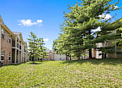 Thumbnail 45 of 65 - Beautifully landscaped community grounds featuring mature trees, open green space, and apartment homes with private balconies at Steeplechase at Shiloh Crossing Apartments in Avon, Indiana.
