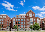 Thumbnail 4 of 58 - A large red brick building with multiple windows and doors.