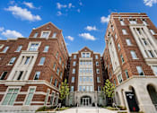 Thumbnail 1 of 58 - A large red brick building with a clear blue sky in the background.