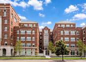 Thumbnail 3 of 58 - A large red brick building with a tree in front.