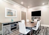 Thumbnail 6 of 7 - Modern resident conference room with sleek furnishings, a large table, and a mounted TV at Village at Almand Creek apartments in Conyers, GA. Perfect for meetings and remote work.