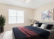 Thumbnail 2 of 7 - Spacious bedroom with large window, natural light, and modern decor at Village at Almand Creek apartments in Conyers, GA. Features plush carpeting and contemporary design.
