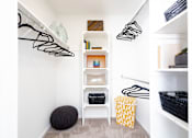 Thumbnail 25 of 38 - a walk in closet with white walls and shelves and a staircase with black and white