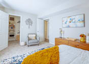 Thumbnail 21 of 38 - a bedroom with a bed and a chair and a closet
