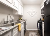 Thumbnail 2 of 38 - a kitchen with granite counter tops and black appliances