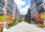 Thumbnail 24 of 53 - a courtyard between two apartment buildings with a bridge