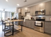 Thumbnail 40 of 53 - a kitchen with gray cabinets and stainless steel appliances