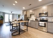 Thumbnail 43 of 53 - a large kitchen with stainless steel appliances and a wooden table with four chairs