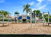 Thumbnail 3 of 10 - A playground with a slide, swings, and a green roofed structure.