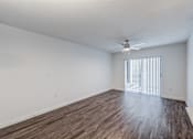 Thumbnail 7 of 10 - A room with wooden flooring and a ceiling fan.