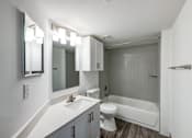 Thumbnail 9 of 10 - A white bathroom with a sink, toilet, and bathtub.