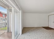 Thumbnail 67 of 74 - A room with a carpeted floor and a door is shown.