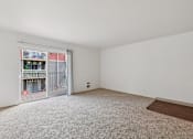 Thumbnail 72 of 74 - A room with a carpeted floor and a sliding glass door leading to a balcony.