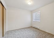 Thumbnail 57 of 74 - A room with a carpeted floor and a window with blinds.