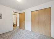Thumbnail 56 of 74 - A room with a carpeted floor and two wooden doors.