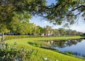 Thumbnail 9 of 24 - Large lake with grass and fence at Banyan Pointe, Florida