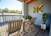 Thumbnail 9 of 15 - A wooden chair and table set up on a porch at Troutdale Terrace, Troutdale, OR, 97060