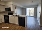 Thumbnail 11 of 13 - A kitchen with black appliances and white cabinets.