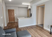 Thumbnail 7 of 13 - A living room with a grey sofa and a wooden door.