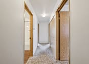 Thumbnail 61 of 74 - A hallway with a carpeted floor and white walls.