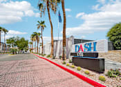 Thumbnail 3 of 22 - Property entrance sign with palm trees at Dash Apartments, Las Vegas, Nevada