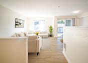 Thumbnail 1 of 15 - A living room with a couch, a plant, and a framed picture on the wall at Troutdale Terrace, Troutdale, OR