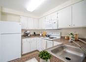 Thumbnail 2 of 15 - A kitchen with white appliances and cabinets at Troutdale Terrace, 97060