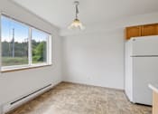 Thumbnail 52 of 74 - A room with a window, a tiled floor, and a white refrigerator.