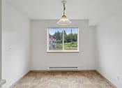 Thumbnail 53 of 74 - A room with a large window showing a view of houses and trees.