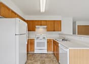 Thumbnail 29 of 74 - A kitchen with white appliances and wooden cabinets  at The Timbers by Vintage, Arlington, 98223