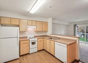 Thumbnail 5 of 48 - A kitchen with wooden cabinets and white appliances.at Vintage at Vancouver, Vancouver, 98662
