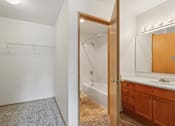 Thumbnail 36 of 74 - A bathroom with a white tub and wooden cabinets.