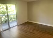 Thumbnail 13 of 24 - A room with wooden flooring and a sliding glass door.at OTAVON APARTMENTS, Novato, 94947
