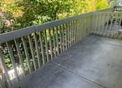 Thumbnail 16 of 24 - A concrete balcony with a white railing.at OTAVON APARTMENTS, California