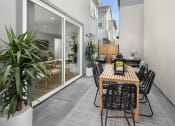 Thumbnail 10 of 35 - Spacious Patio with Table and Chairs, Area Rug, Potted Plants, Patio Chairs, and Sliding Glass Door to Interior of Apartment at Solstice at Fiddyment Ranch, Roseville, CA, 95747